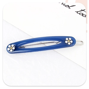 Détail de la pince à cheveux en acétate bleu Klein avec fleurs et clip métallique