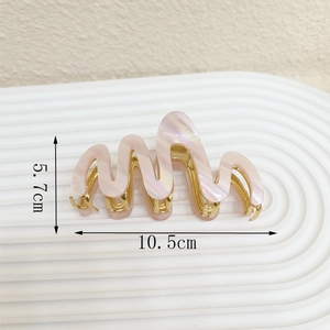 Detail view of pink wave acetate hair claw clip with dimensions 10.5cm and 5.7cm