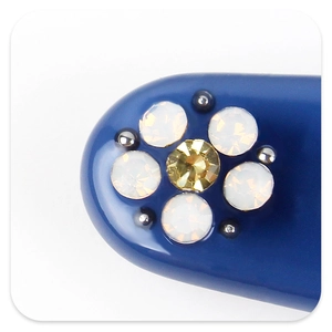 Détail de la barrette en acétate bleu avec fleur d'opale et centre en cristal jaune