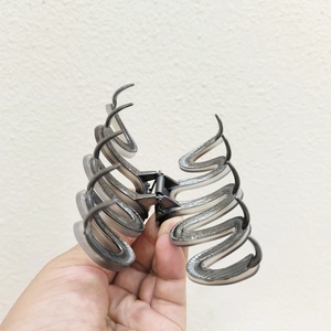 Close-up of a large smoke grey acetate hair claw clip with wave spiral teeth and metal spring