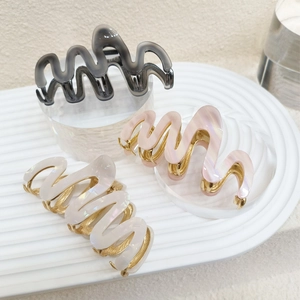 Minimalist wavy acetate hair claw clips in grey pink and white with gold metal teeth
