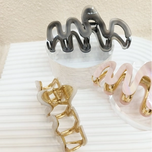 Detail of wavy acetate hair clips with strong metal springs in multiple colors