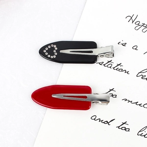 Lot de deux barrettes en acétate, noir avec cœur en strass et rouge brillant uni