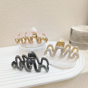 Set of large wavy acetate hair claws in pink, grey, and black with marble texture finish