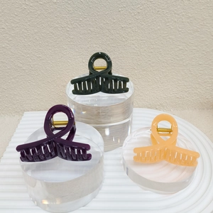 Trois pinces à cheveux en plastique coloré sur des supports en acrylique, décor épuré
