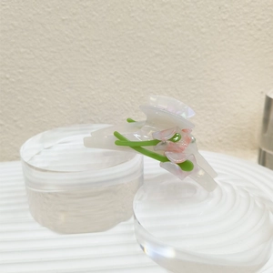 Detailed view of the acetate lily flower hair claw clip with pink tulips on white