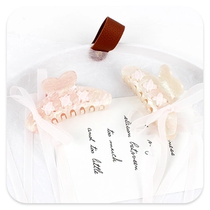 Detail showing glitter acrylic shark clips with elegant ribbon streamers on art card