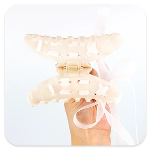 Macro shot of a light pink acrylic hair claw with elegant chiffon ribbon weaving detail