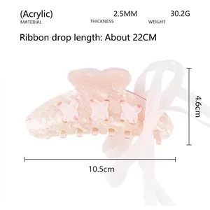 Detail view of pink glitter acrylic hair claw clip with dimensions and ribbon length info