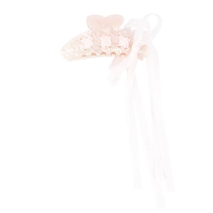 Detail of pink glitter acrylic hair claw clip with long white silk ribbon streamers