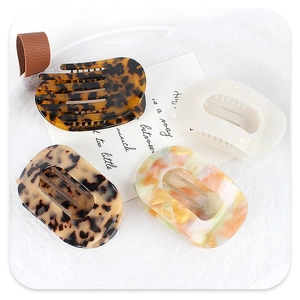 Detail view of four elegant acetate hair claws in tortoise shell and marble patterns