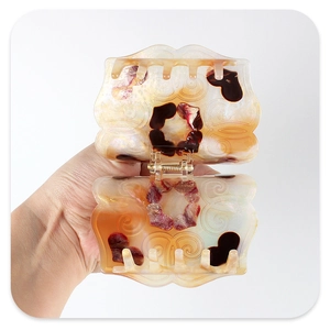 Detail view of large acetate claw clip with heart patterns and gold metal spring