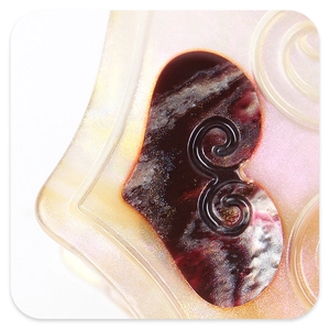 Detailed close-up of acetate hair claw showing pearlescent texture and purple heart detail