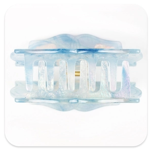 Macro detail of the light blue marble acetic acid hair claw clip with golden metal spring