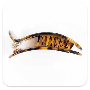 Detail view of arched hair claw clip featuring classic brown tortoiseshell texture