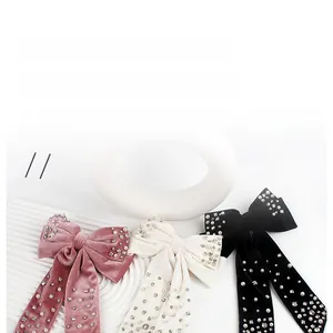 Macro shot of velvet bow hair clips with embedded pearls and sparkling rhinestones