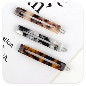 Three acetate hair clips in tortoiseshell and marble patterns with cutout design