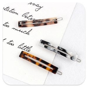 Close-up of three acetate hair clips in tortoise shell and marble patterns