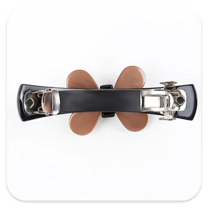 Détail d'une barrette à cheveux en acétate noir avec un nœud en cristal brun et ressort