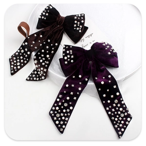 Detail of velvet bow hair clips with white pearls and sparkling rhinestones