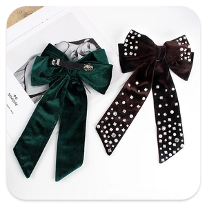Detail of velvet bow hair clip with luxury pearl and rhinestone embellishments