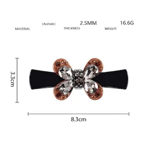 Vue détaillée de la pince à cheveux papillon en acétate noir avec des strass