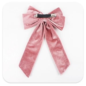 Detail of the silver metal spring clip on the back of a pink velvet bow hairpin