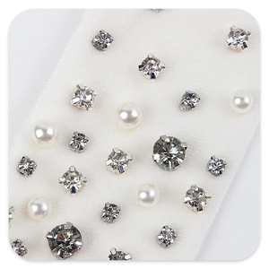 Macro shot of assorted rhinestone and faux pearl stud earrings in various sizes and settings