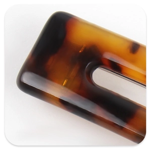 Macro view showing the classic tortoise shell pattern and glossy acetate texture of this hair clip
