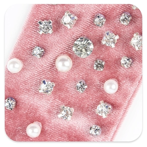 Close-up of pink velvet bow with embedded rhinestones and pearls on hair accessory