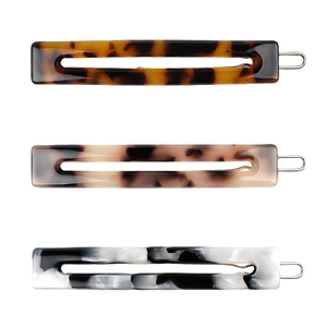 Three hollow rectangular acetate hair clips in tortoise, marble, and ink patterns
