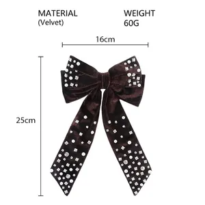 Detailed view of dark brown velvet bow hair clip with white pearls and shiny rhinestones