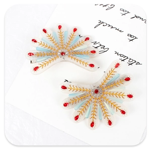 Détail d'une pince à cheveux en éventail avec cristaux rouges et motifs dorés ciselés