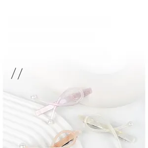 Detailed macro view of pearl spring hair clips with a cross design and pearlescent texture