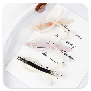 Detail view of acetate resin pearl hair clips set with cross pattern and back clip mechanism