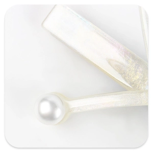 Detail view of pearlescent acetate hair clip with glitter finish and elegant pearl accent