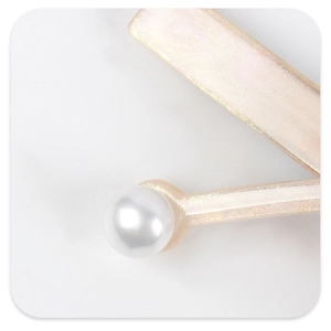 Detailed macro view of acetate hair clip with pearl decor and champagne shimmer finish