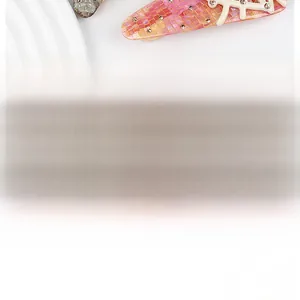 Macro shot of pink mosaic acetate hair clip with gold rivets and white hollow structure