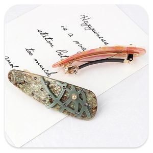 Detail of branch shaped hair clips with acetate texture, rhinestones and faux pearls