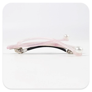 Detail of pink acetate hair clip with white pearls and cross design on white background
