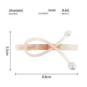Detail showing acetate hair clip dimensions 8.8cm by 5.5cm with elegant pearl accents