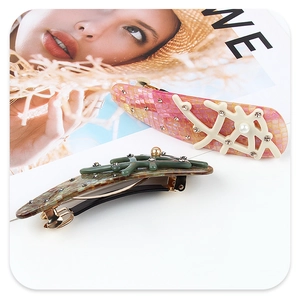 Detailed view of hair clips with coral-shaped textures, rhinestones, and small pearls