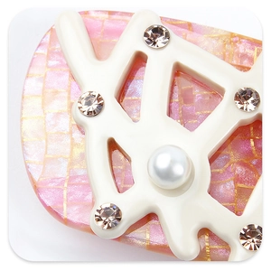 Detailed macro view of acetate branch hair clip with pink mosaic inlay and white faux pearls