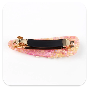 Detail view of pink mosaic acetate hair clip with golden metal spring clasp and grip