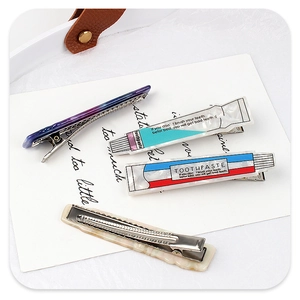 Set of four unique hair clips featuring creative toothpaste tube designs and marble patterns