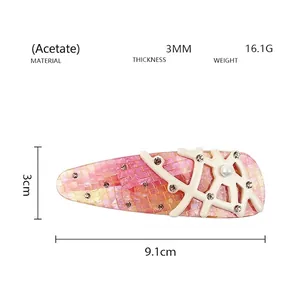 Detail of pink acetate hair clip with mosaic pattern and branch-like crystal inlay