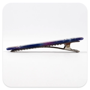Detail view of the metal spring clip and serrated teeth of the nebula pattern hair clip