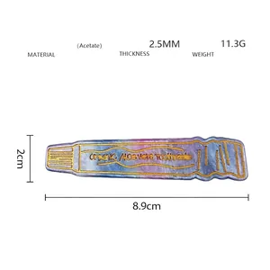 Detailed view of toothpaste shaped hair clip with blue marble acetate and gold text