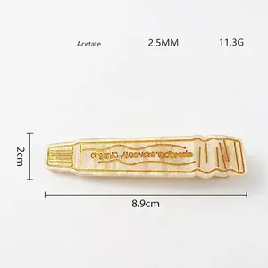 Detail of toothpaste shaped acetate hair clip with golden organic aloe vera text print