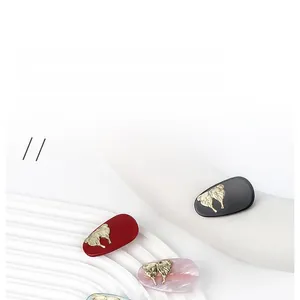 Detail of vintage teardrop hair clips with gold butterfly accents in marble textures